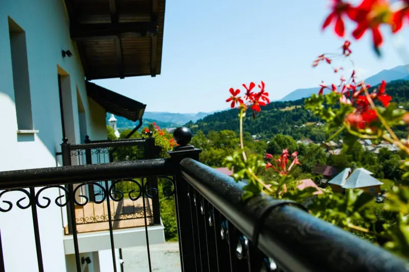 Balustrada balconului, mușcate și dealurile din jur