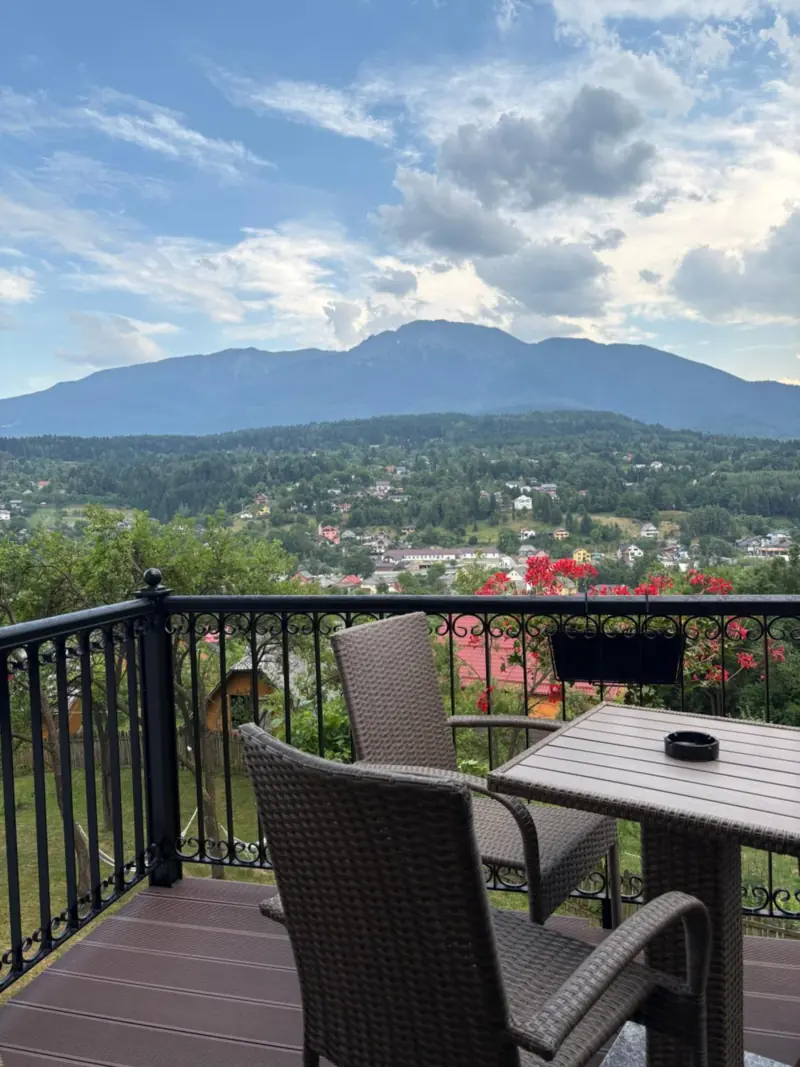 Măsuță și scaune pe balcon, cu muntele în față