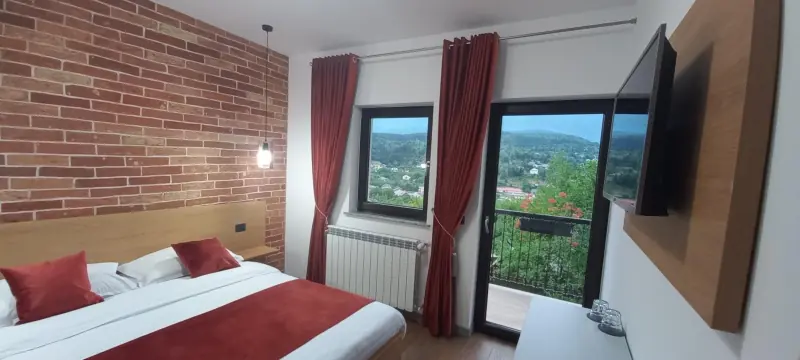 Cameră cu perete de cărămidă și ieșire în balcon
