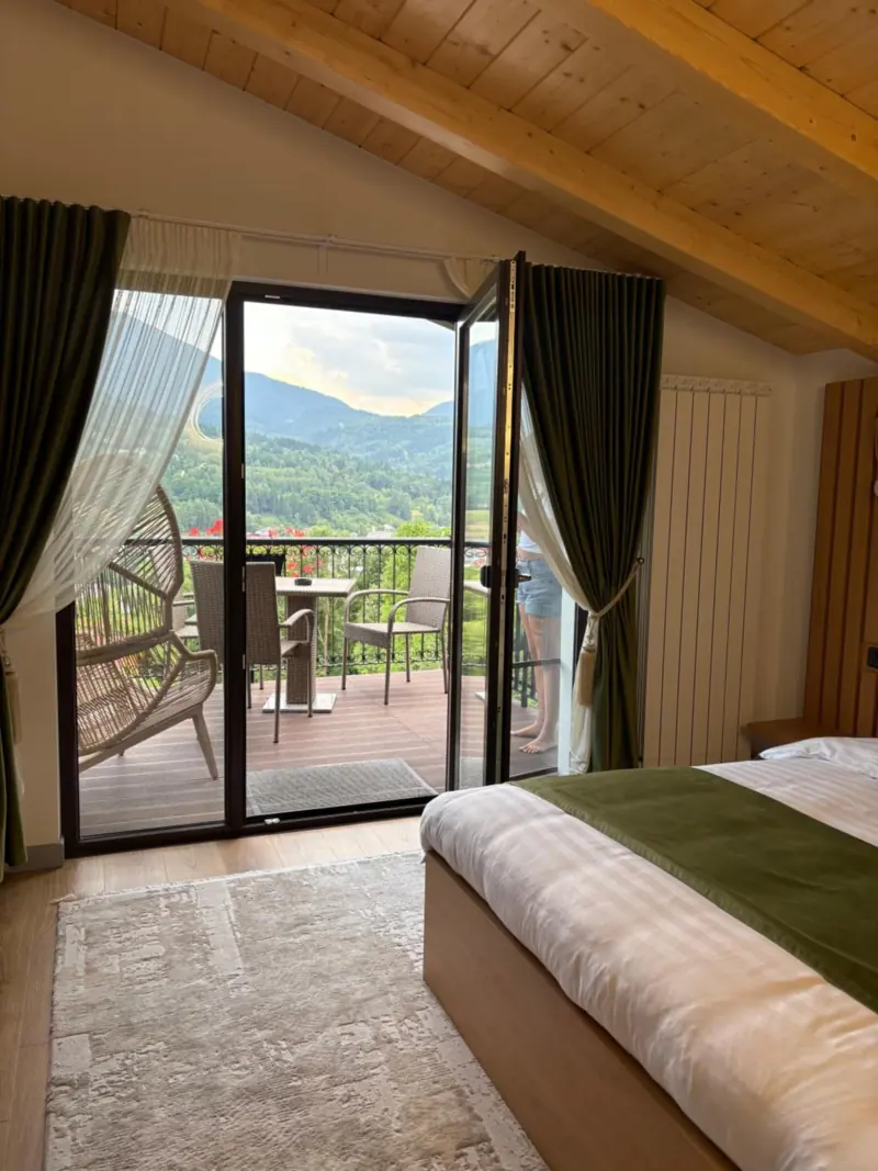 Ușa deschisă spre balcon, cu munții în față