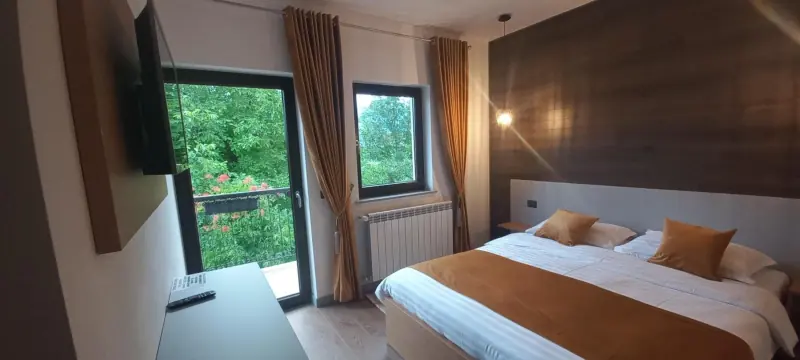 Cameră cu televizor și fereastră spre pădure