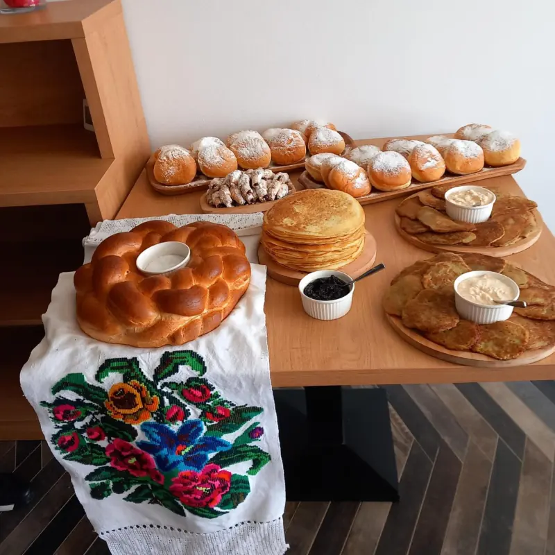 Cozonac, clătite și plăcinte pe o masă cu ștergar maramureșean cusut cu flori