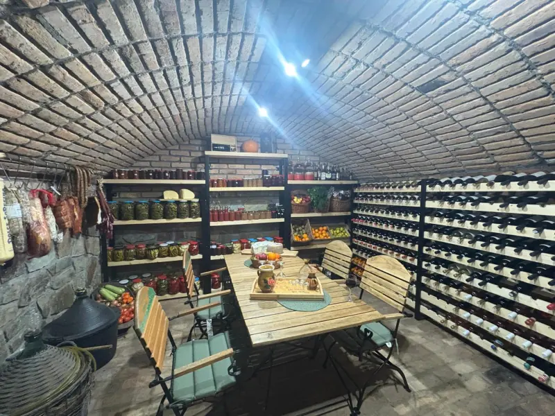 Crama boltită din cărămidă, cu rafturi de vin și borcane